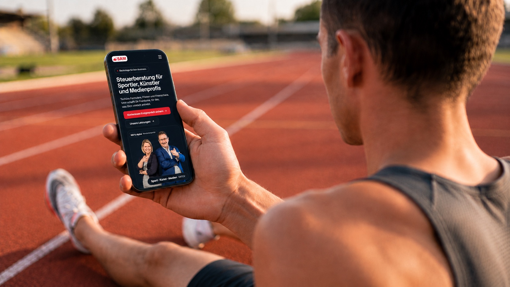 SAM-Steuerberatung-Website auf einem Smartphone, gehalten von einem Laeufer auf der Tartanbahn: „Steuerberatung fuer Sportler, Kuenstler und Medienprofis“
